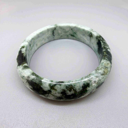Polished jade bangle in soft green hues with smooth surface and natural variations, 20 cm inner circumference