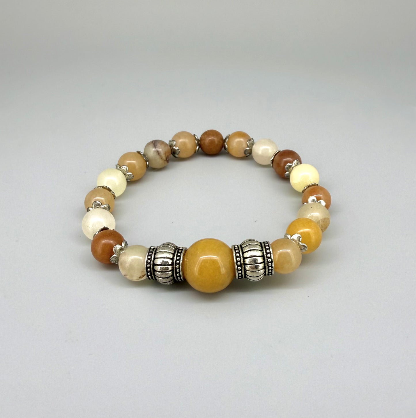 Jade beaded bracelet, 18cm, beige, orange, and brown gemstone beads with larger focal bead and two metal accents on elastic stretch band.