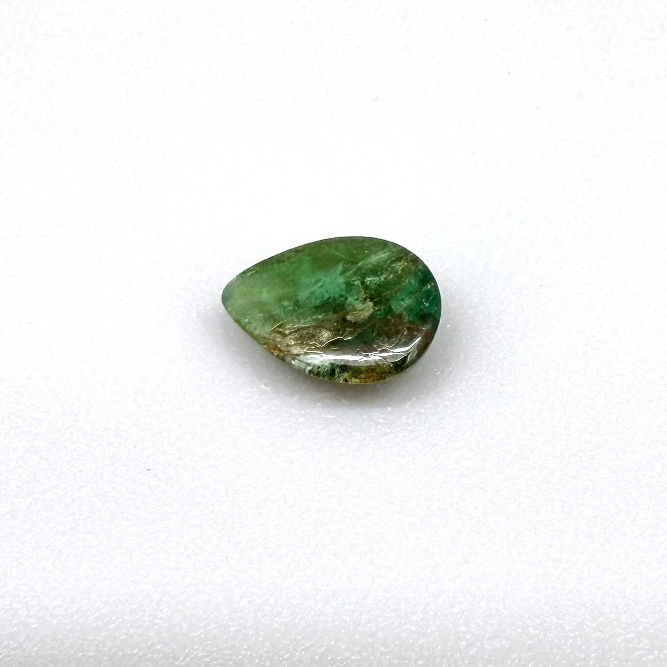 0.82 ct natural untreated emerald from Zambia, one side polished and the other cabochon-shaped.