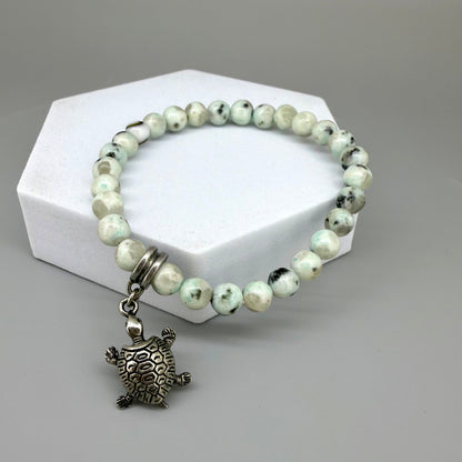 Dalmatian jasper beaded bracelet, 18cm, earthy gemstone beads with metal turtle charm on elastic stretch band.