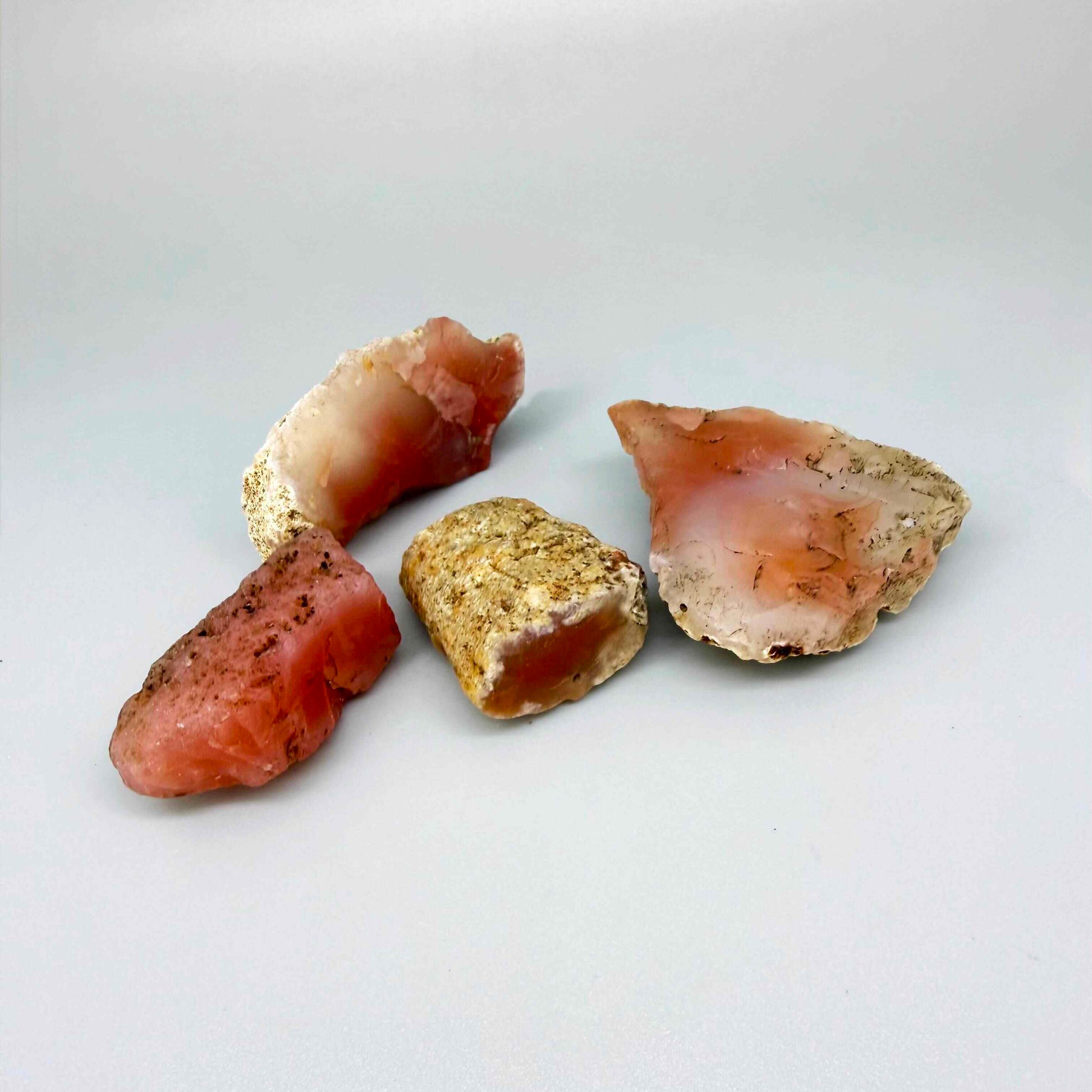 Rough and uncut chalcedony/carnelian lot in natural red-orange tones, untreated raw gemstones.