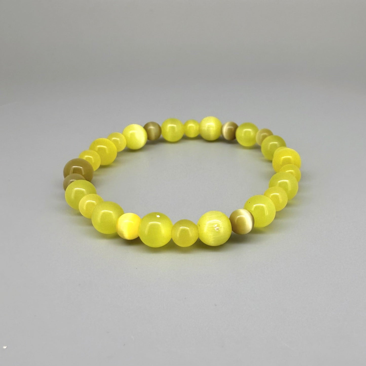 Yellow cat’s eye beaded bracelet, 18cm, shimmering yellow beads with brown accent stones on elastic stretch band.