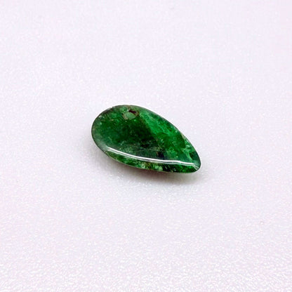 0.9 ct natural untreated emerald from Zambia, one side polished and the other cabochon-shaped.