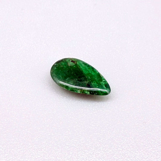 0.9 ct natural untreated emerald from Zambia, one side polished and the other cabochon-shaped.