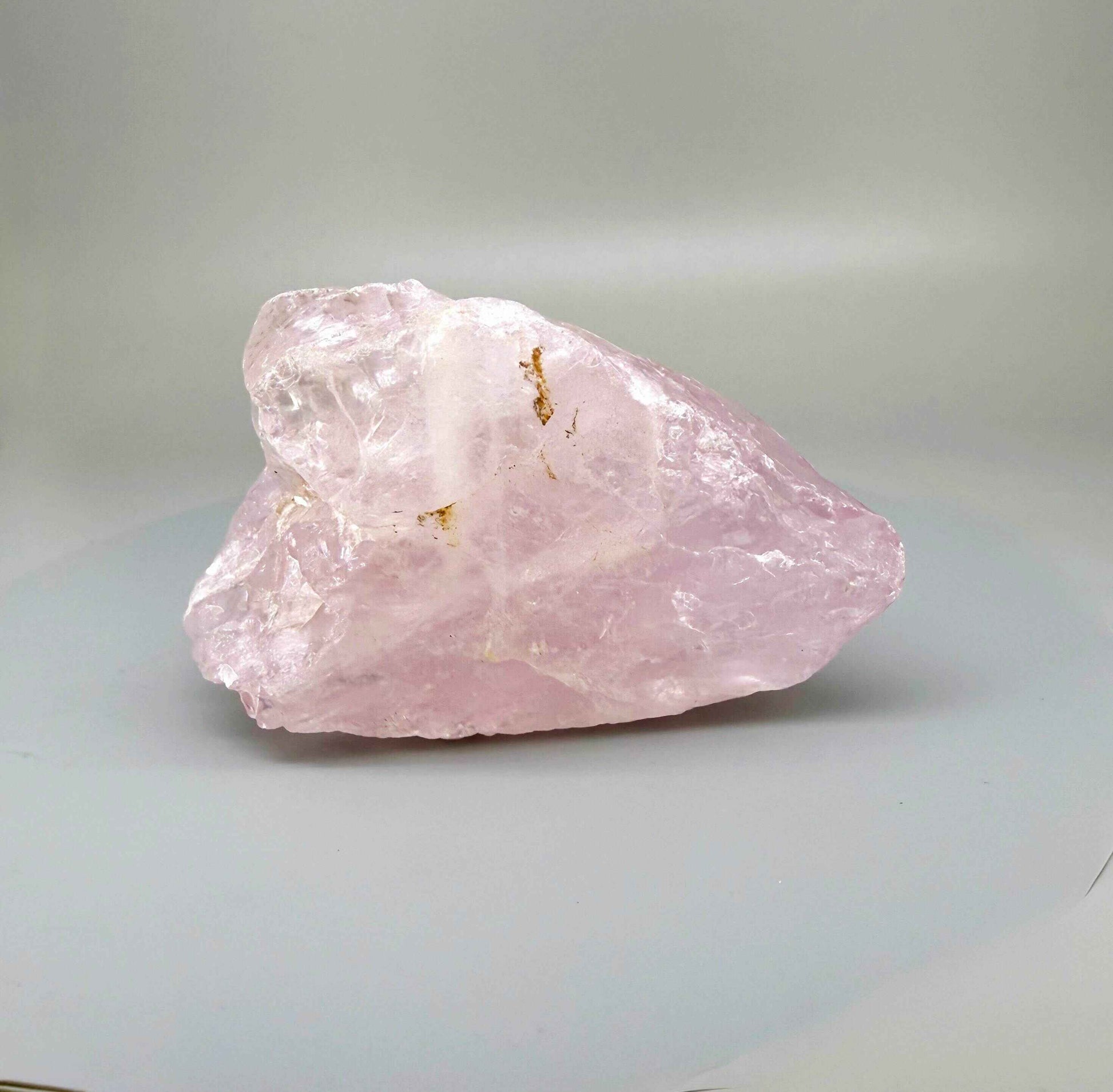 Natural rose quartz rough stone, translucent untreated pink quartz in raw form photographed in natural light