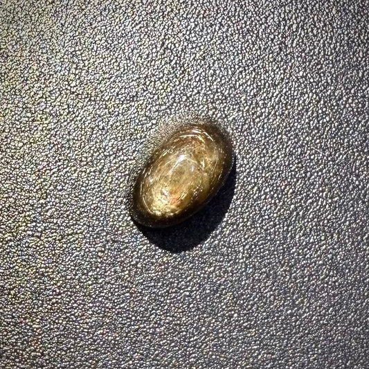 Golden-brown star sapphire cabochon, natural gemstone with subtle asterism