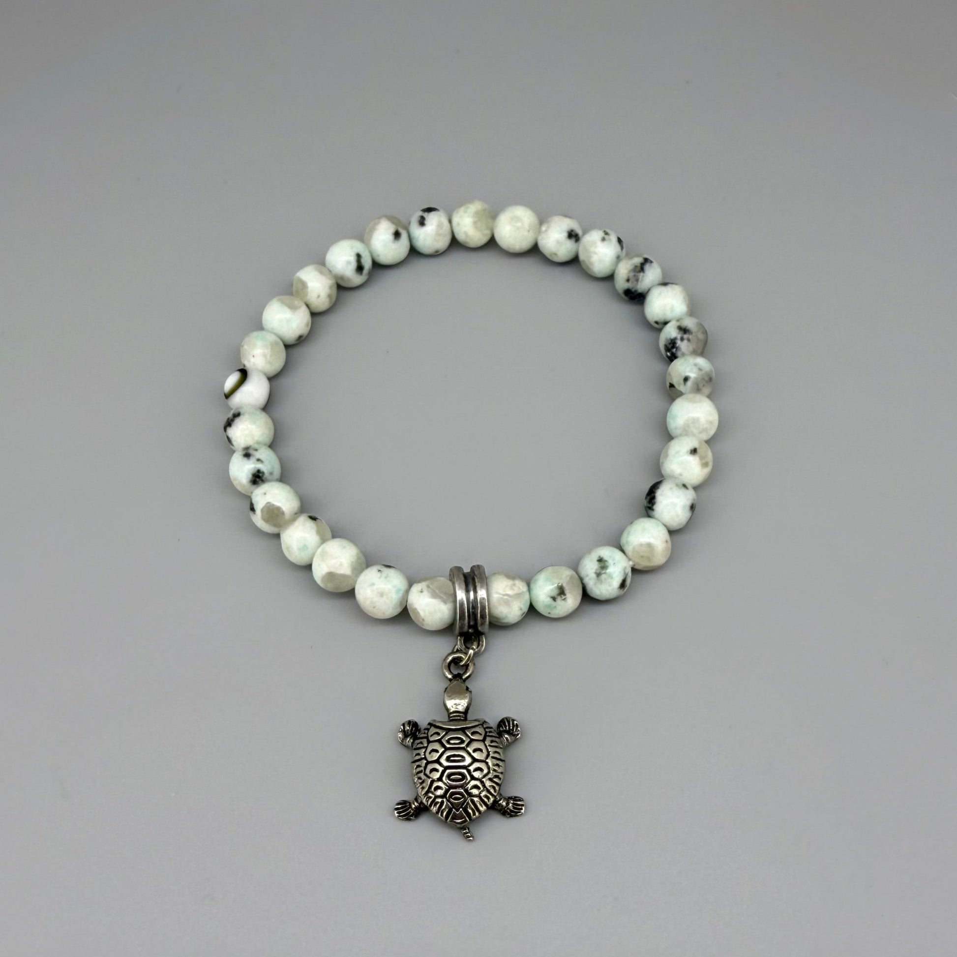 Dalmatian jasper beaded bracelet, 18cm, earthy gemstone beads with metal turtle charm on elastic stretch band.