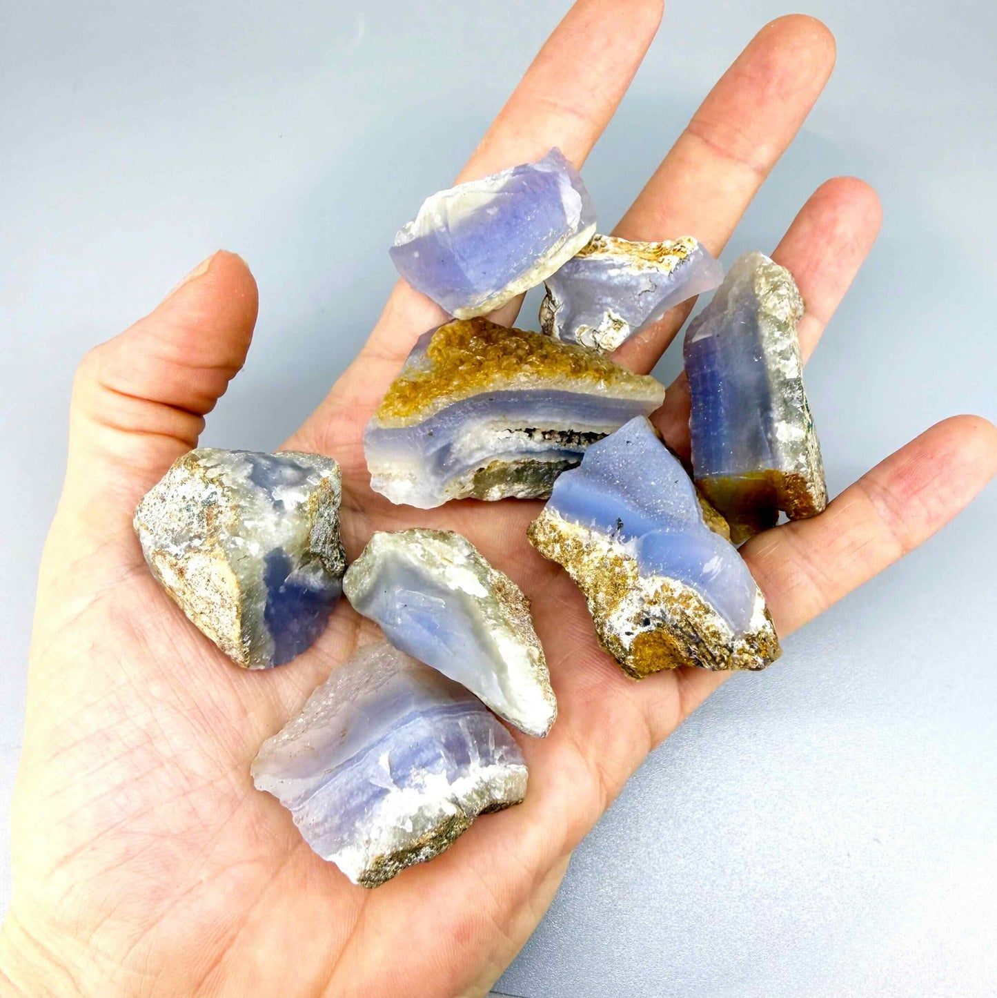 Untreated blue chalcedony rough lot with milky appearance and natural banding