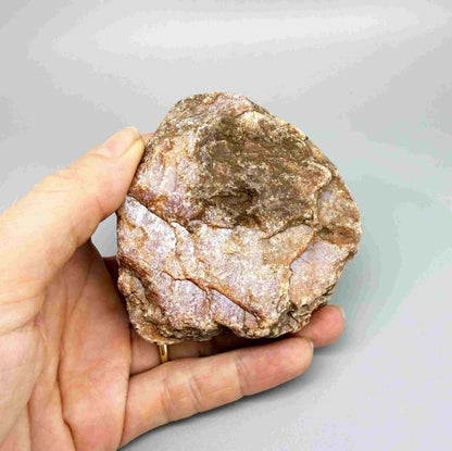 Natural ruby rough stone with purple-pink tones in host rock, uncut corundum specimen