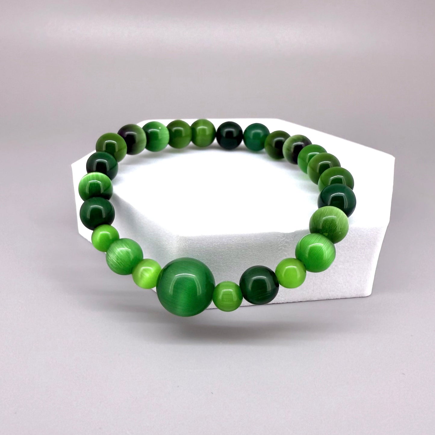 Green cat’s eye beaded bracelet, 18cm, shimmering green gemstone beads with one larger focal bead on elastic stretch band.
