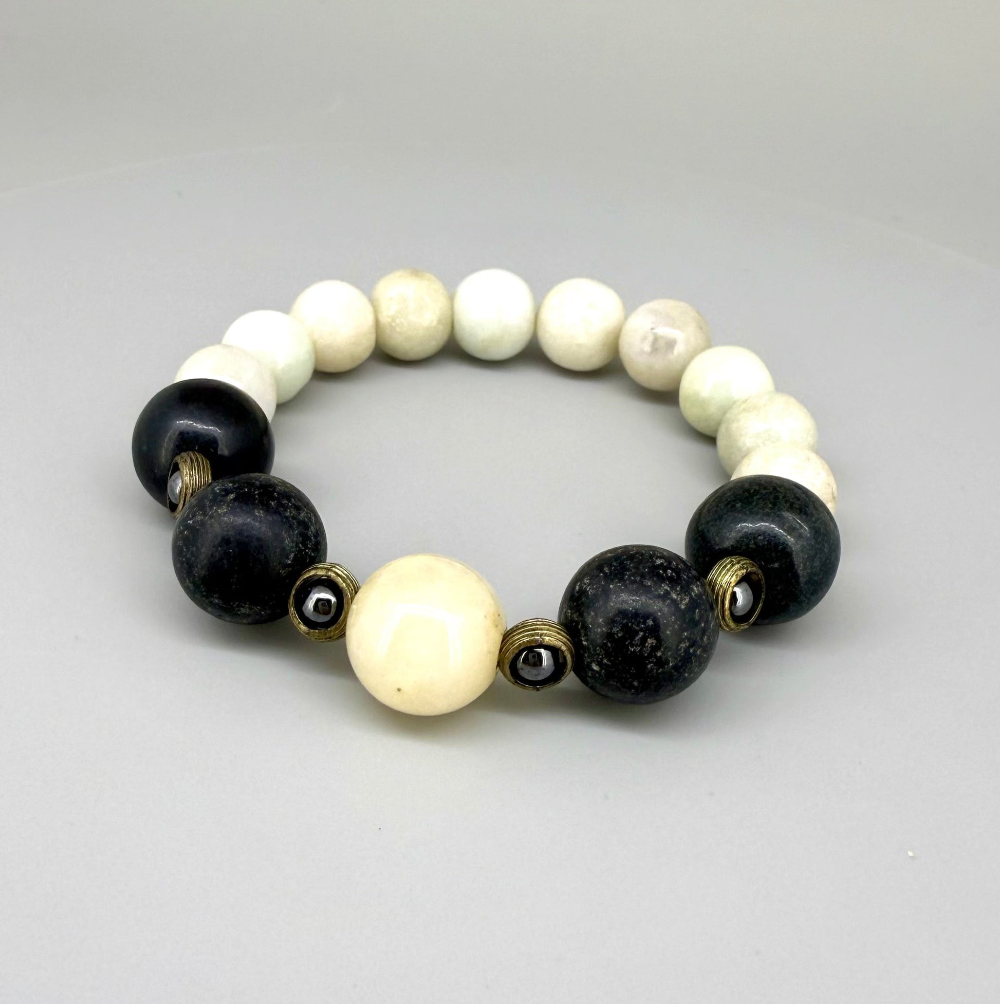 White jade, onyx, and hematite beaded bracelet, 18cm, natural white, black, and metallic grey gemstone beads with smaller hematite accents on elastic stretch band.