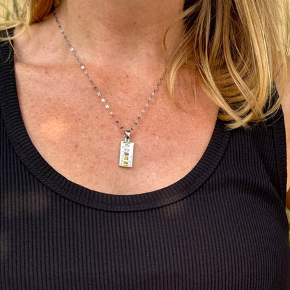 Handmade pendant featuring 0.8 ct fancy sapphires in yellow, pink, and blue, set in white-gold-plated sterling silver.