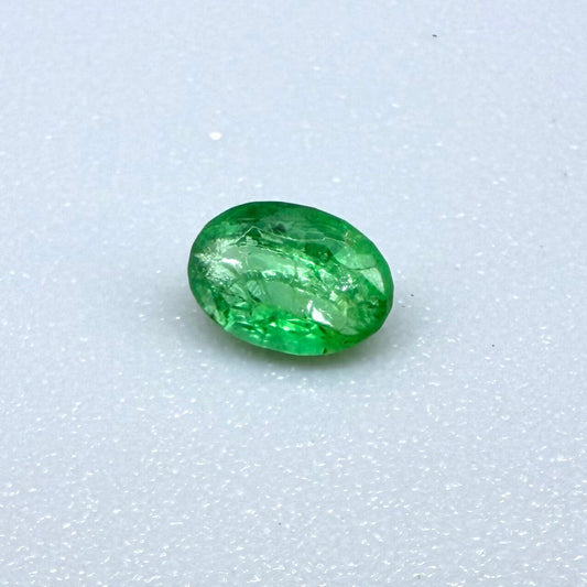 0.22 ct natural untreated Zambian emerald, oval faceted with vivid bluish-green color.
