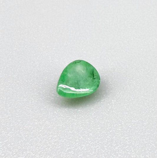 0.51 ct natural untreated emerald from Zambia, one side polished and the other cabochon-shaped.