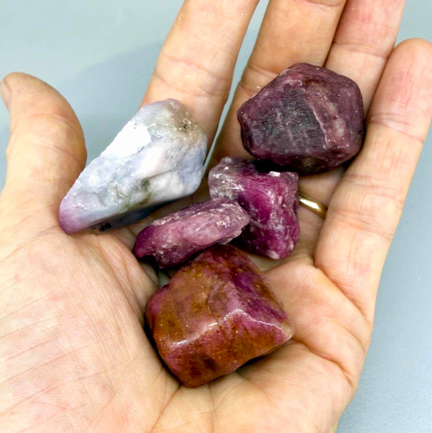 Natural ruby rough lot with pink to purplish-pink and raspberry tones, uncut corundum stones.