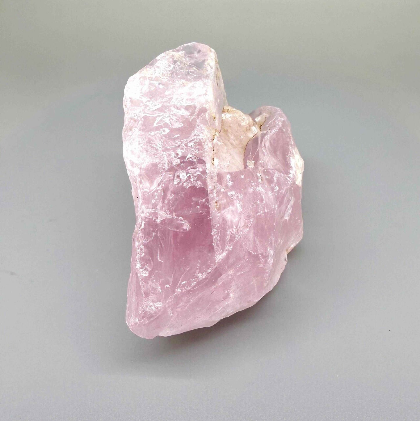 Natural rose quartz rough stone, translucent untreated pink quartz in raw form photographed in natural light