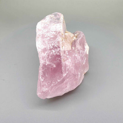 Natural rose quartz rough stone, translucent untreated pink quartz in raw form photographed in natural light