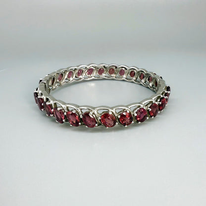 Rhodolite garnet bangle in sterling silver with white gold plating on neutral background