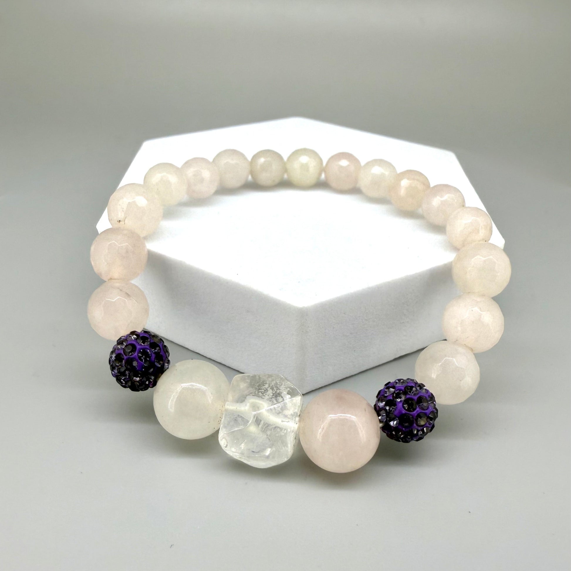 Rose quartz beaded bracelet, 19cm, light pink gemstone beads with larger central rose quartz bead and black sparkling accent beads on elastic stretch band.