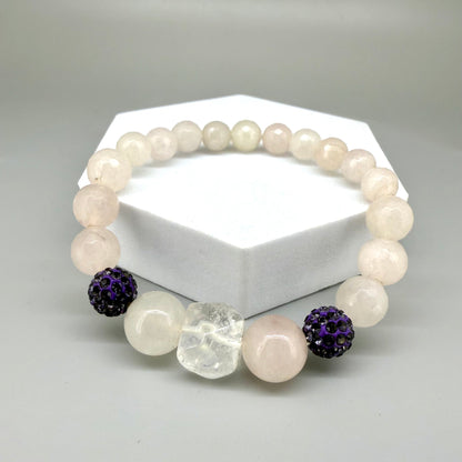 Rose quartz beaded bracelet, 19cm, light pink gemstone beads with larger central rose quartz bead and black sparkling accent beads on elastic stretch band.