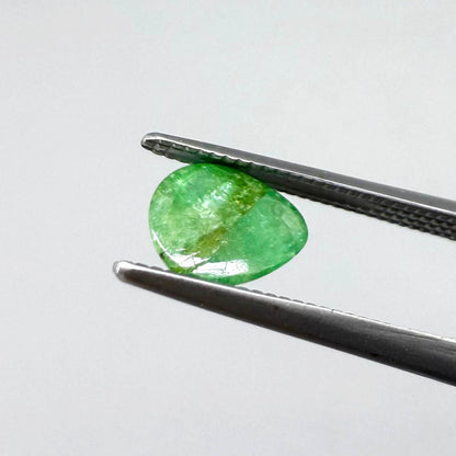 0.75 ct natural untreated emerald from Zambia, one side polished and the other cabochon-shaped.