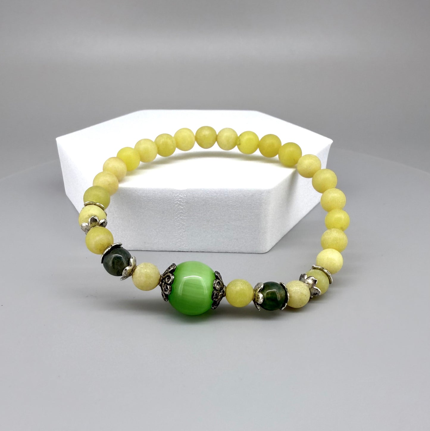 Yellow jade beaded bracelet, 18cm, with larger green jade focal bead on elastic stretch band.