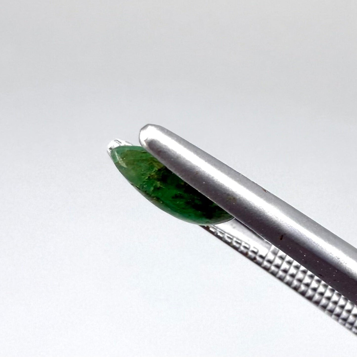 0.82 ct natural untreated emerald from Zambia, one side polished and the other cabochon-shaped.