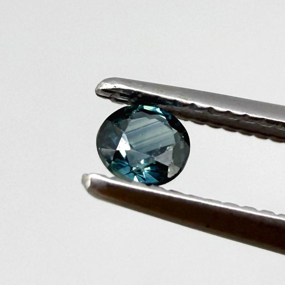 0.15 ct natural greenish-blue sapphire from Bangkaja, round cut.