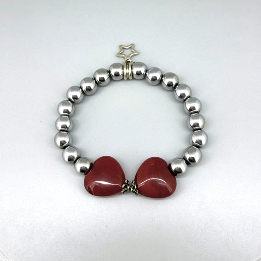 Silver hematite beaded bracelet, 18cm, metallic gemstone beads with two orange-red heart-shaped carnelian accents on elastic stretch band.