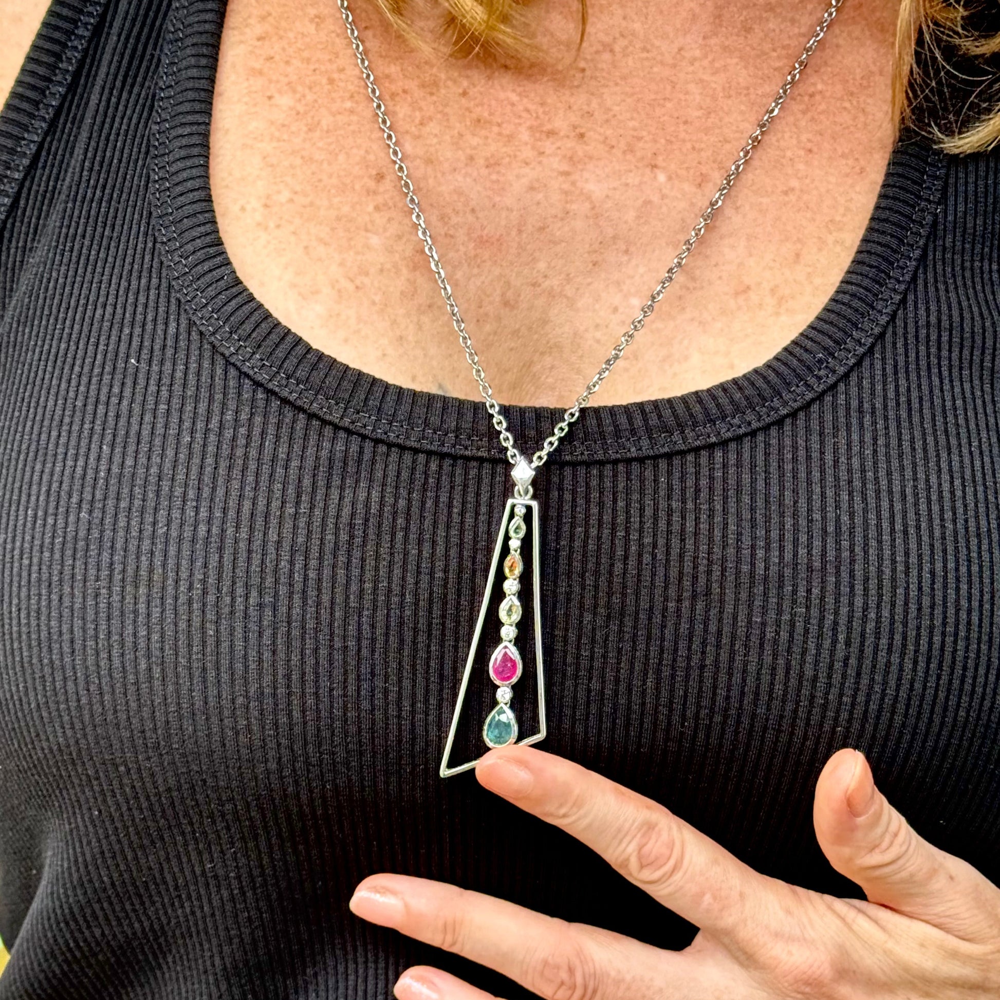 Handmade white gold plated silver pendant featuring 1.97 ct sapphires and 1.32 ct rubies in a modern geometric design with a freely moving gemstone strand.