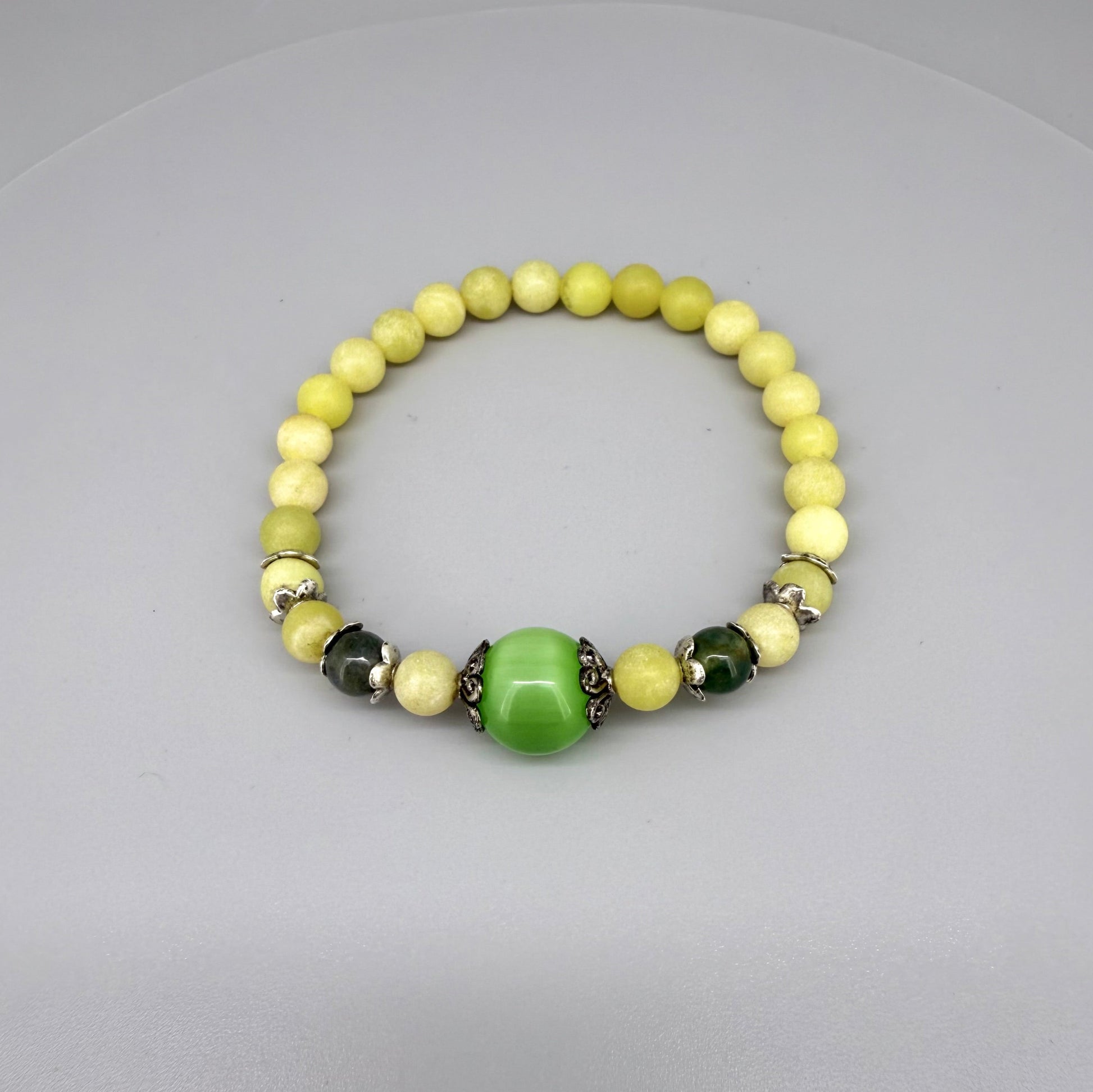 Yellow jade beaded bracelet, 18cm, with larger green jade focal bead on elastic stretch band.