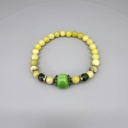 Yellow jade beaded bracelet, 18cm, with larger green jade focal bead on elastic stretch band.