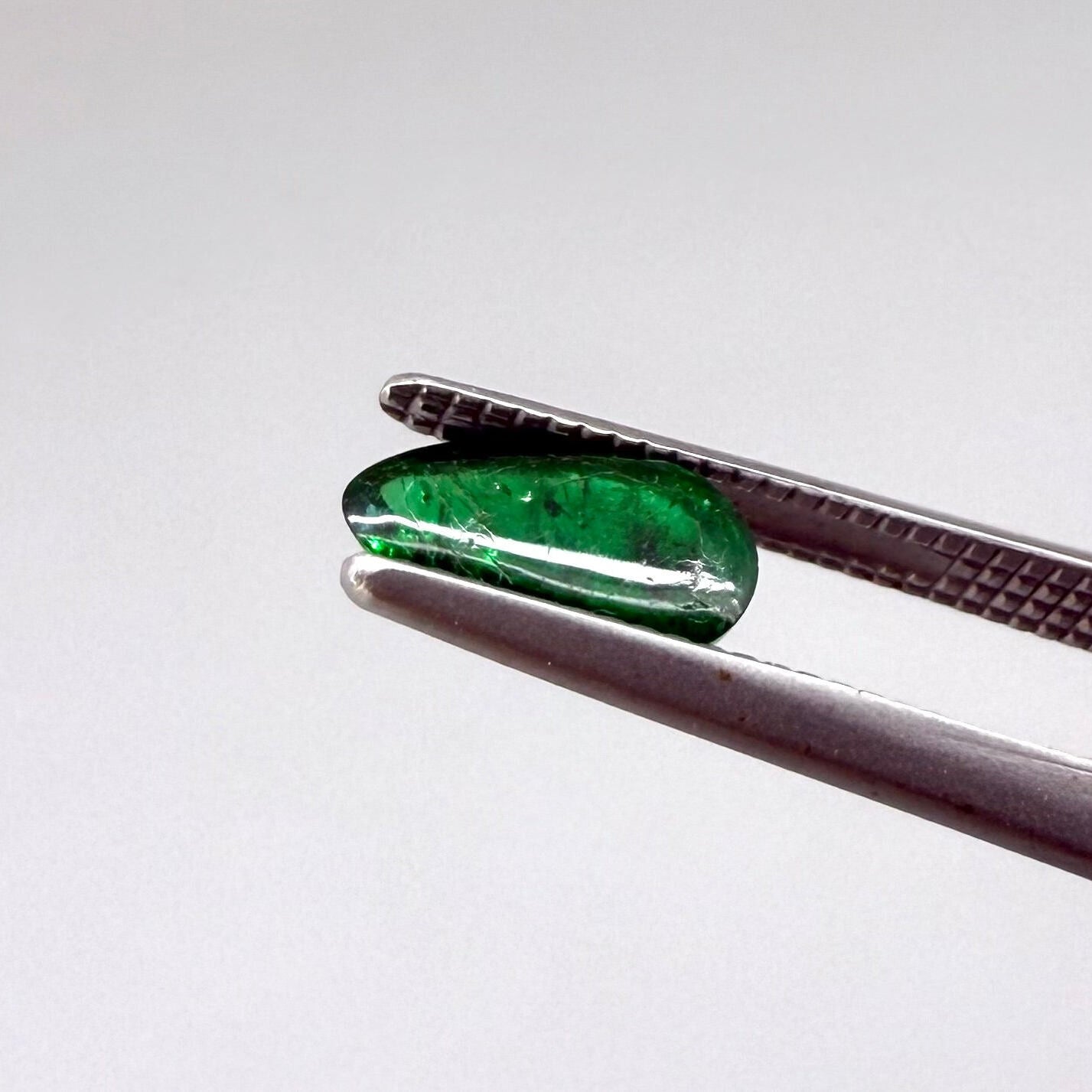 0.67 ct natural untreated emerald from Zambia, one side polished and the other cabochon-shaped.