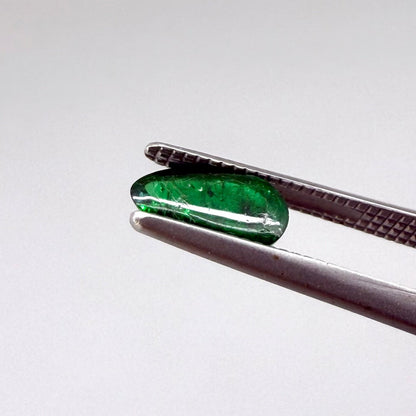 0.67 ct natural untreated emerald from Zambia, one side polished and the other cabochon-shaped.