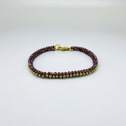 18 cm beaded bracelet made of wine-red garnet and gold-toned hematite with a lobster clasp, displayed on a light background.