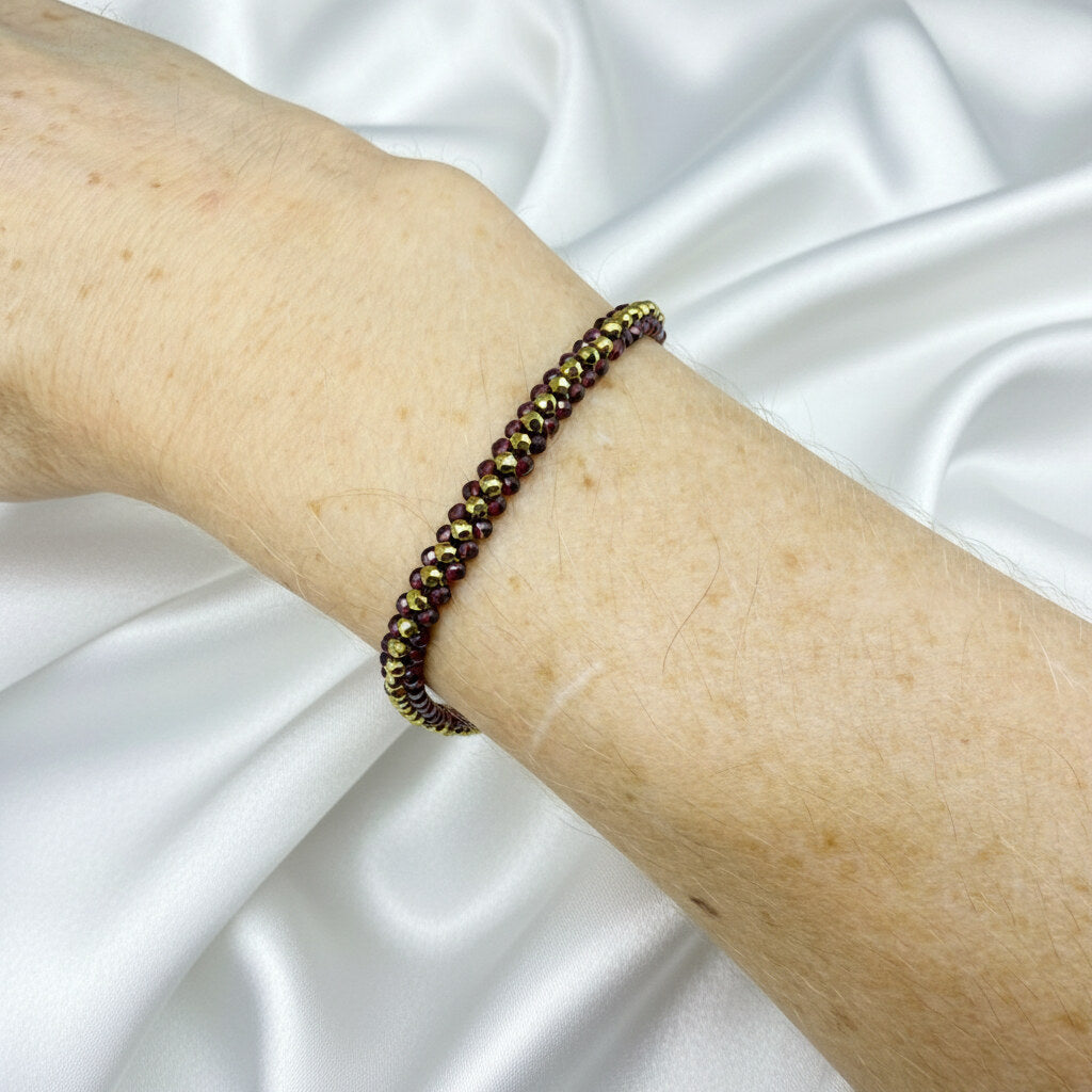 18 cm beaded bracelet made of wine-red garnet and gold-toned hematite with a lobster clasp, displayed on a light background.