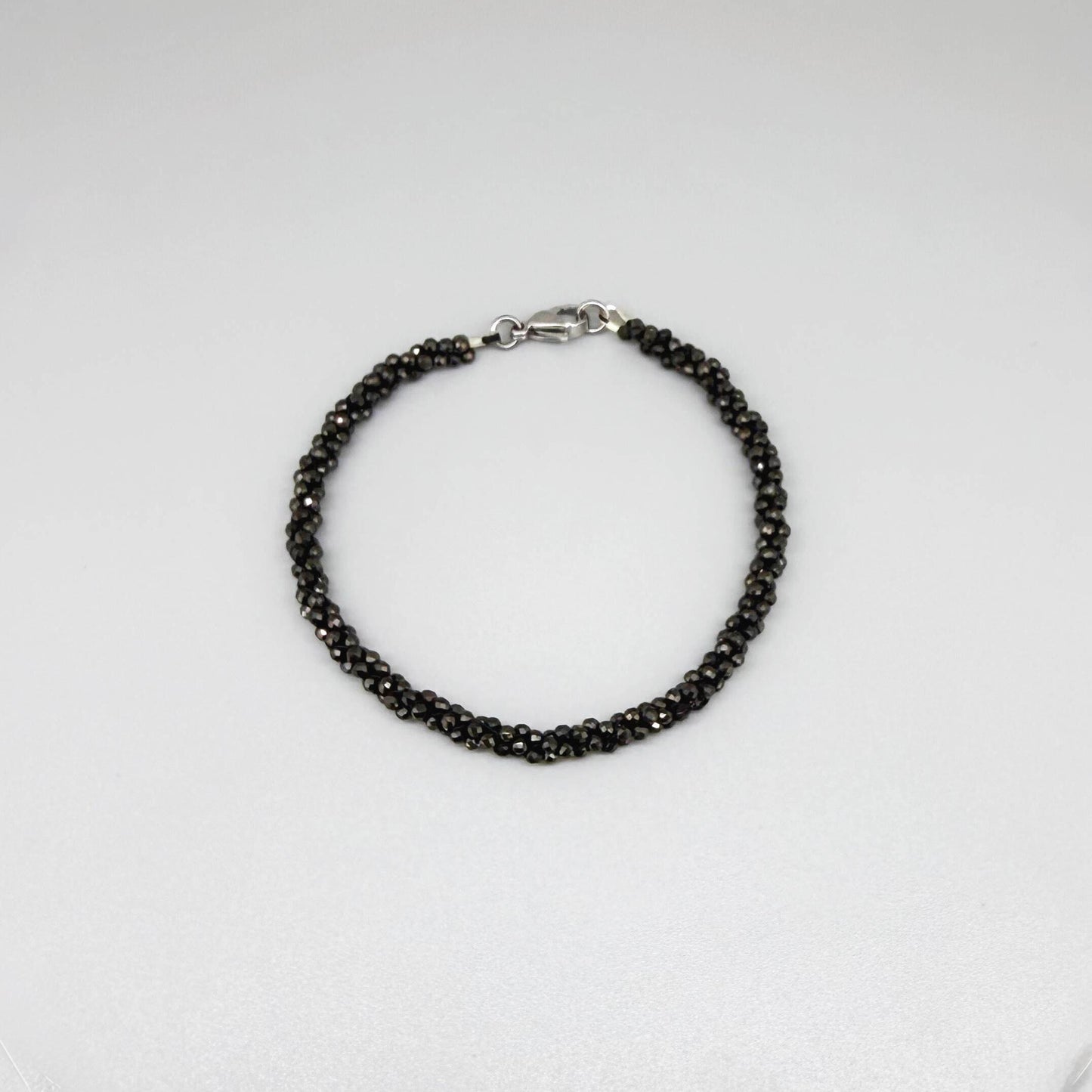 20 cm beaded bracelet made of faceted near-black hematite with a lobster clasp, displayed on a light background.