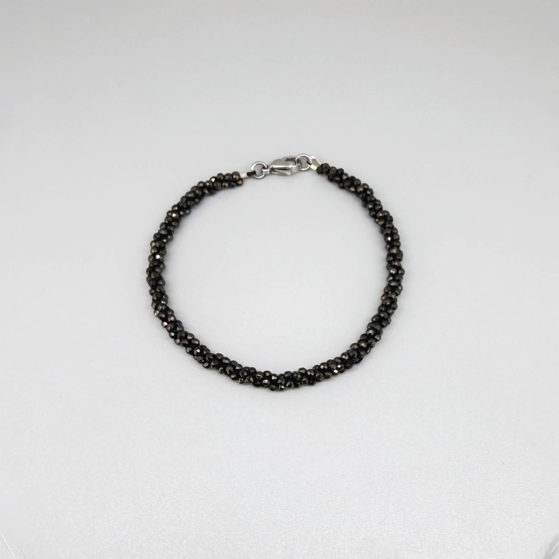 20 cm beaded bracelet made of faceted near-black hematite with a lobster clasp, displayed on a light background.