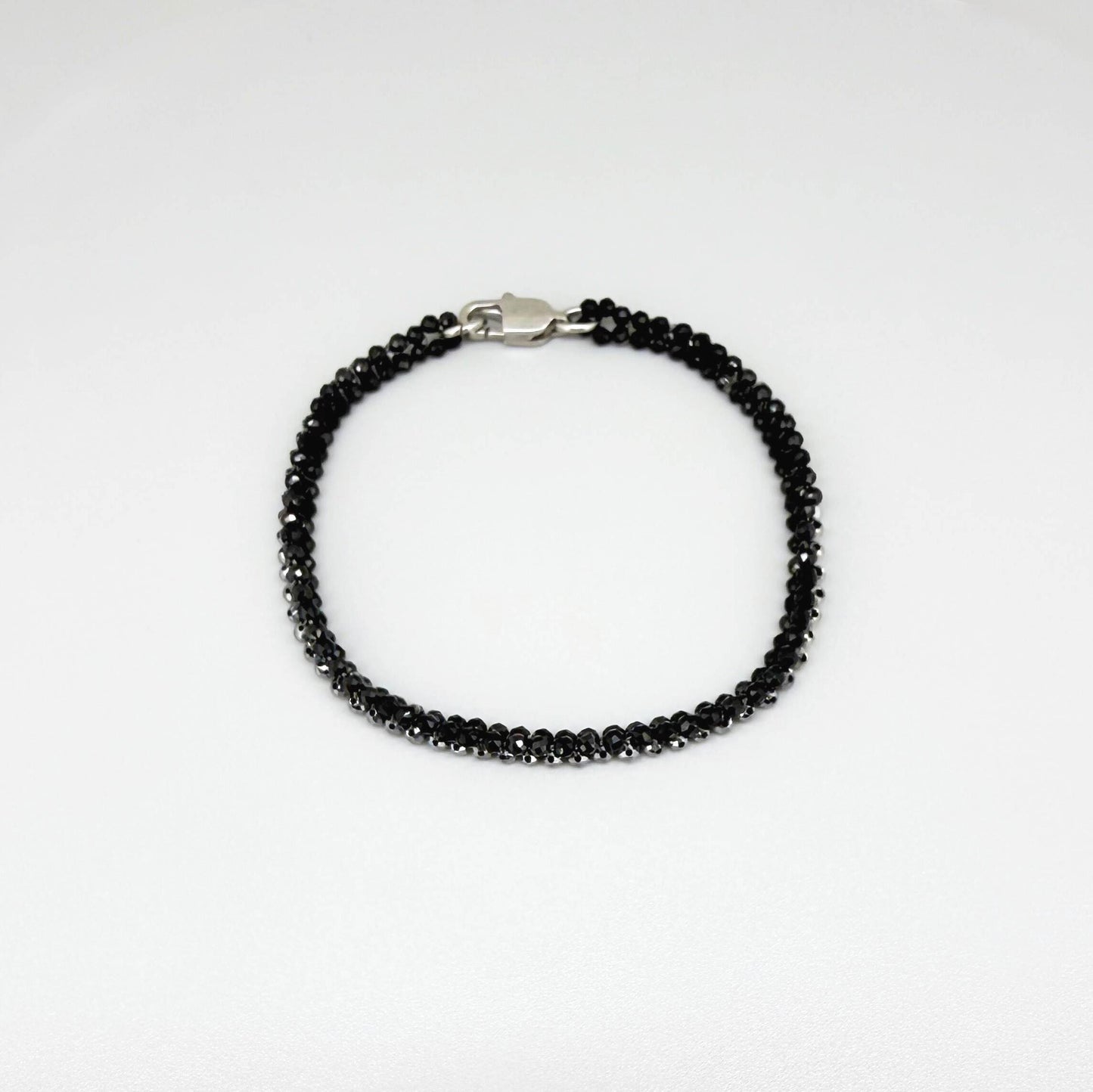 18 cm bracelet made from faceted black spinel and silver hematite beads with a lobster clasp.