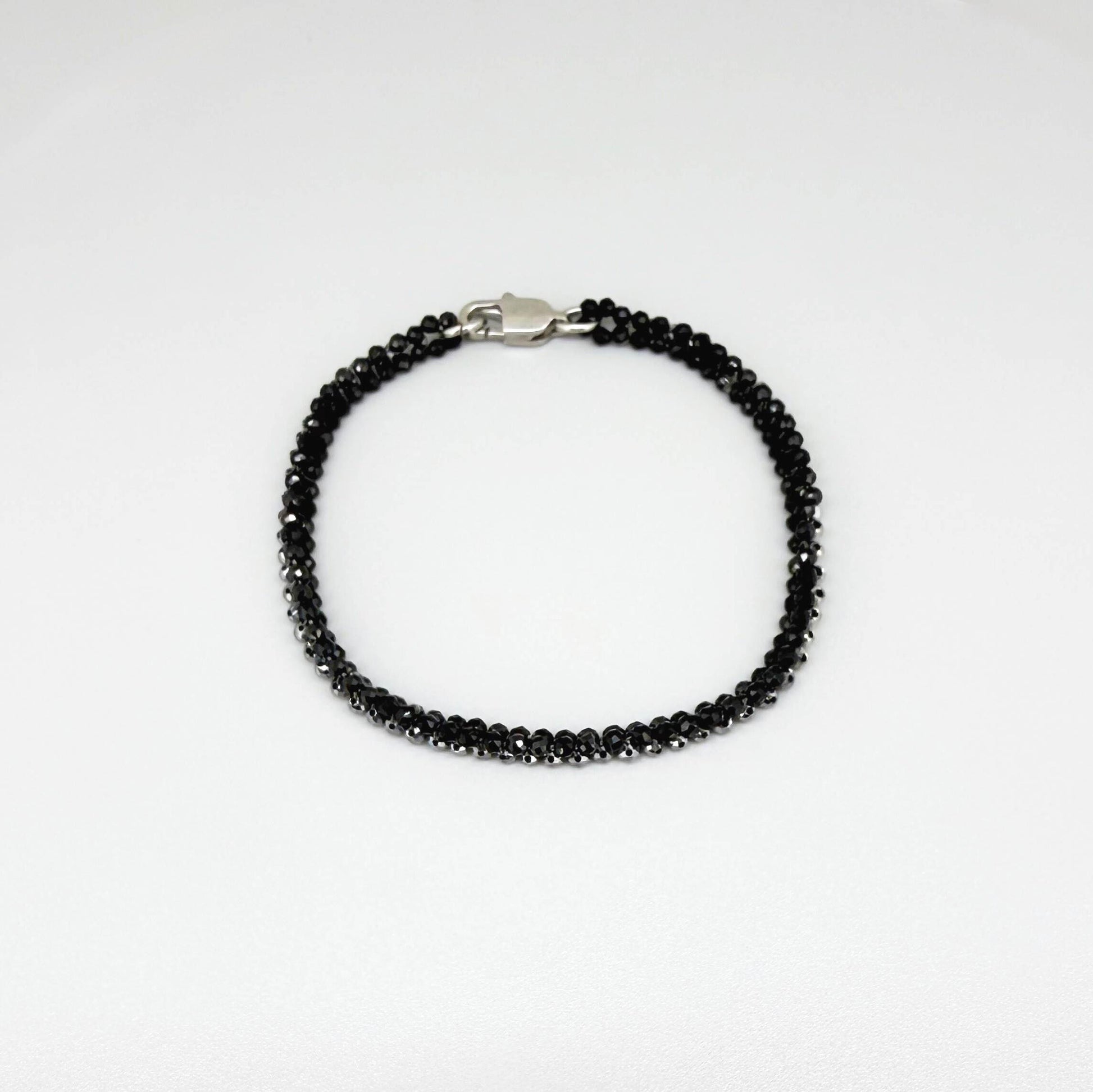 18 cm bracelet made from faceted black spinel and silver hematite beads with a lobster clasp.