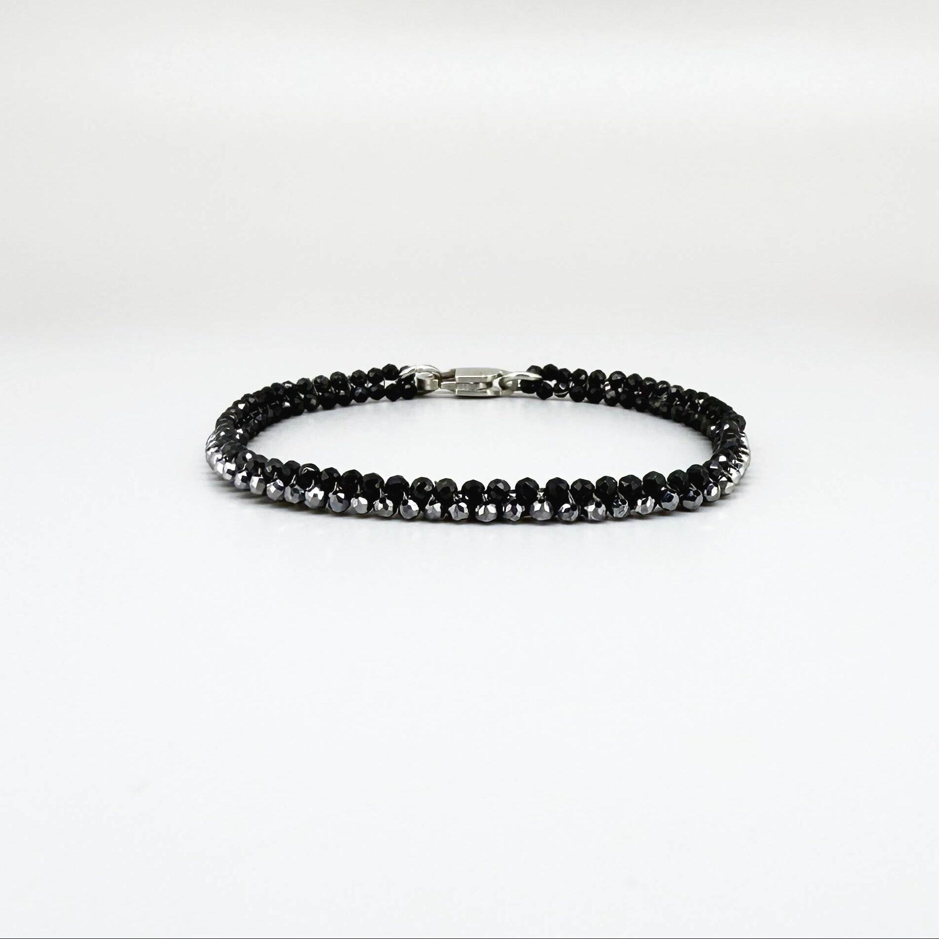 18 cm bracelet made from faceted black spinel and silver hematite beads with a lobster clasp.