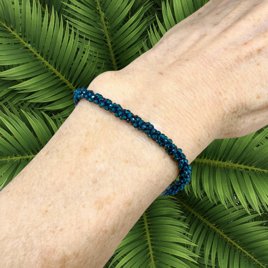 18 cm bracelet made from faceted deep teal apatite beads with a lobster clasp, shown on a light background.