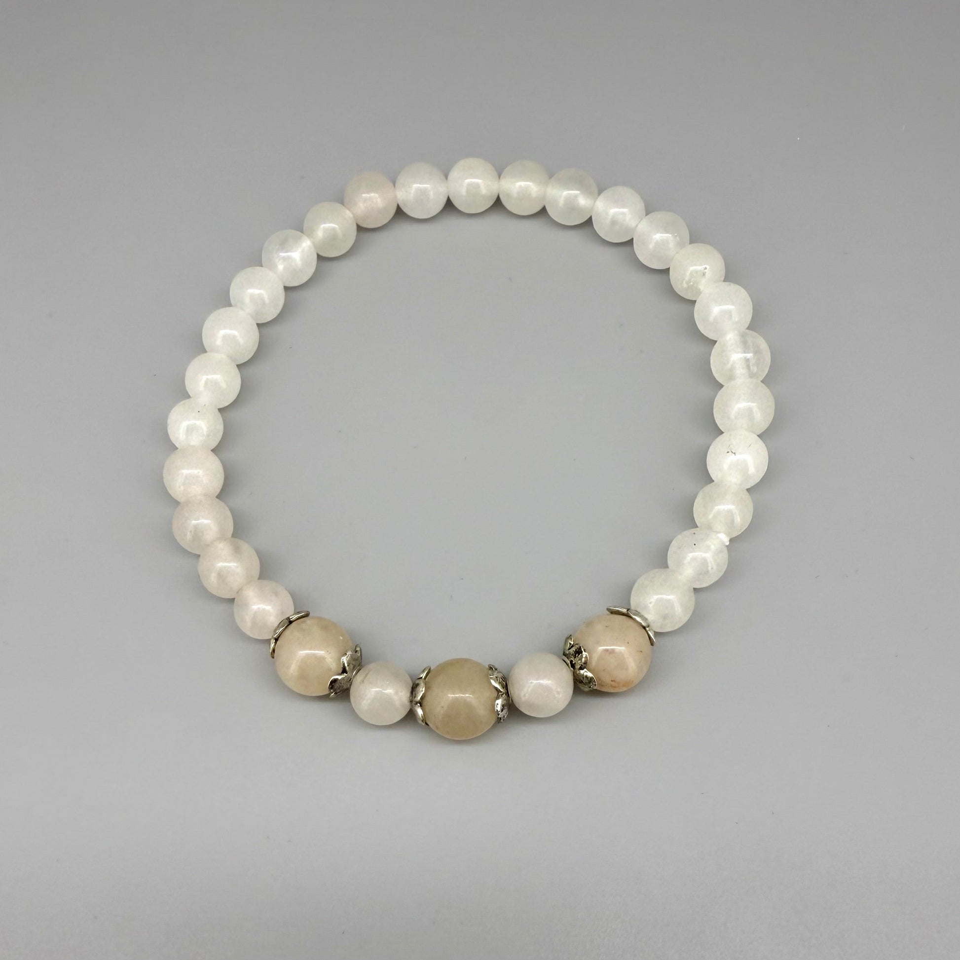 Jade beaded bracelet, 19cm, natural green gemstone beads with three slightly larger darker accent stones on elastic stretch band.
