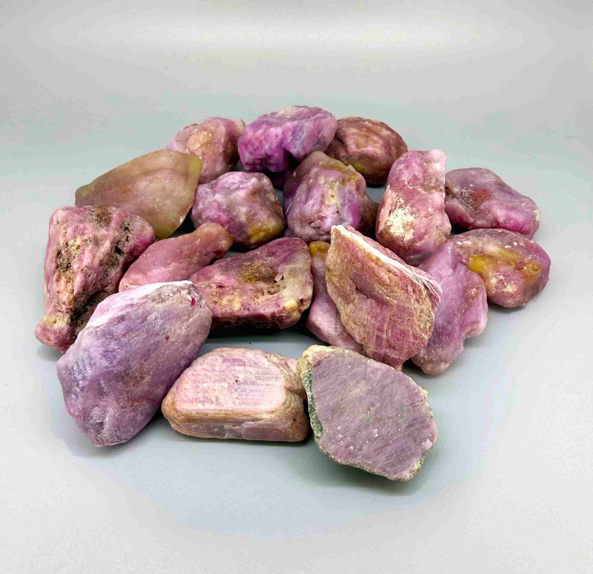 Natural ruby rough lot weighing approximately 1,380 g, featuring pink to lilac-pink corundum stones in raw form.