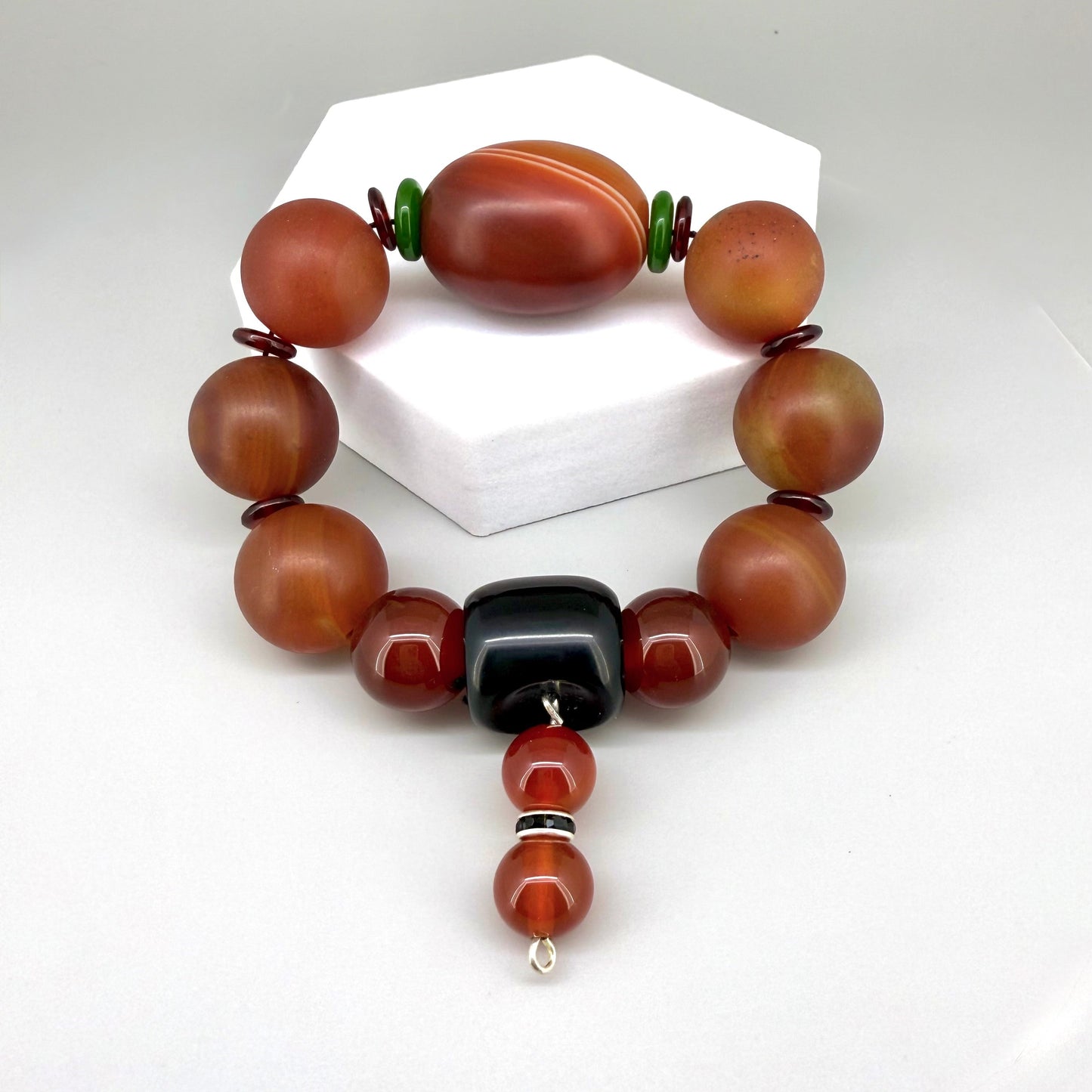 Carnelian and agate beaded bracelet, 20cm, red-orange gemstone beads with large black square bead on elastic stretch band.