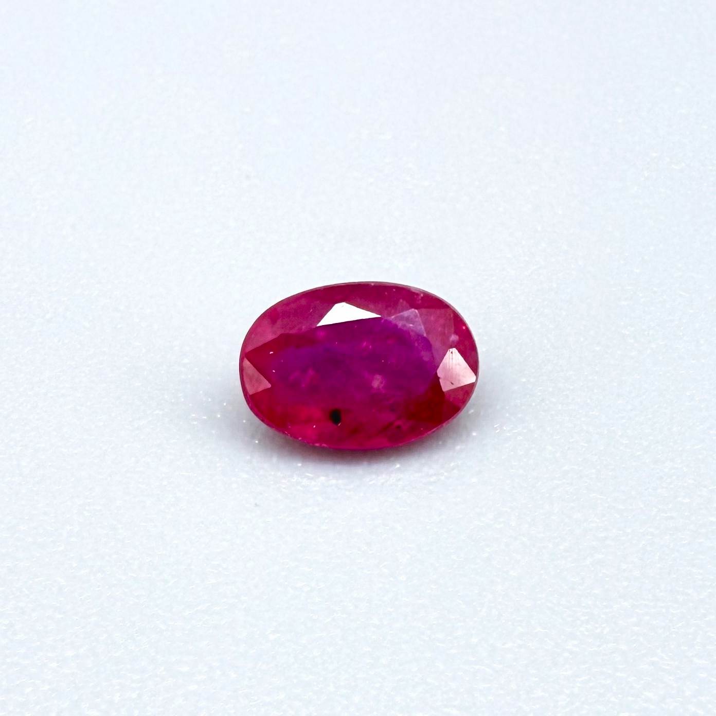 0.6 ct natural Songea ruby, oval cut in a pink-red tone.