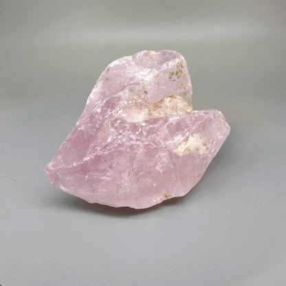 Natural rose quartz rough stone, translucent untreated pink quartz in raw form photographed in natural light