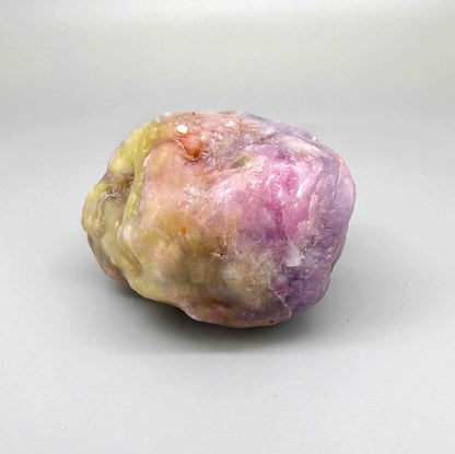 Natural ruby rough stone in lilac to purplish-pink tones, uncut corundum specimen.
