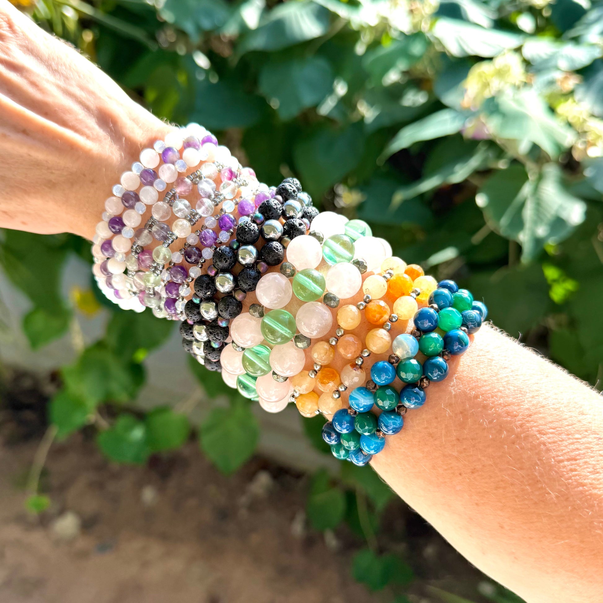 Multicolored beaded bracelets on a wrist with a natural background