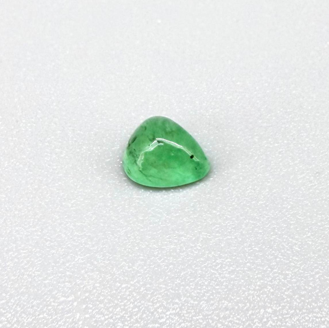 0.51 ct natural untreated emerald from Zambia, one side polished and the other cabochon-shaped.
